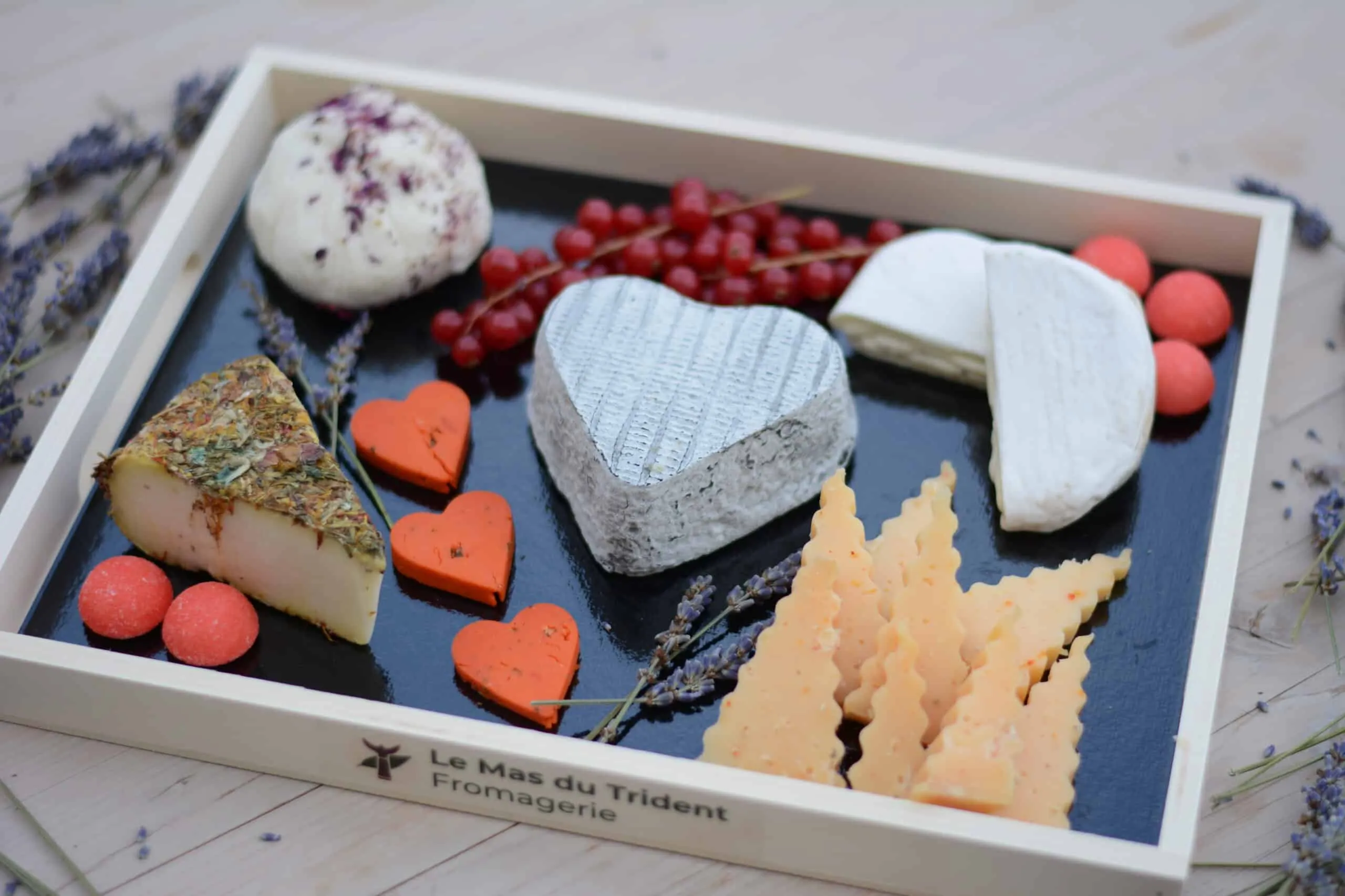 Un plateau de fromages en cœur, décoré de fruits rouges