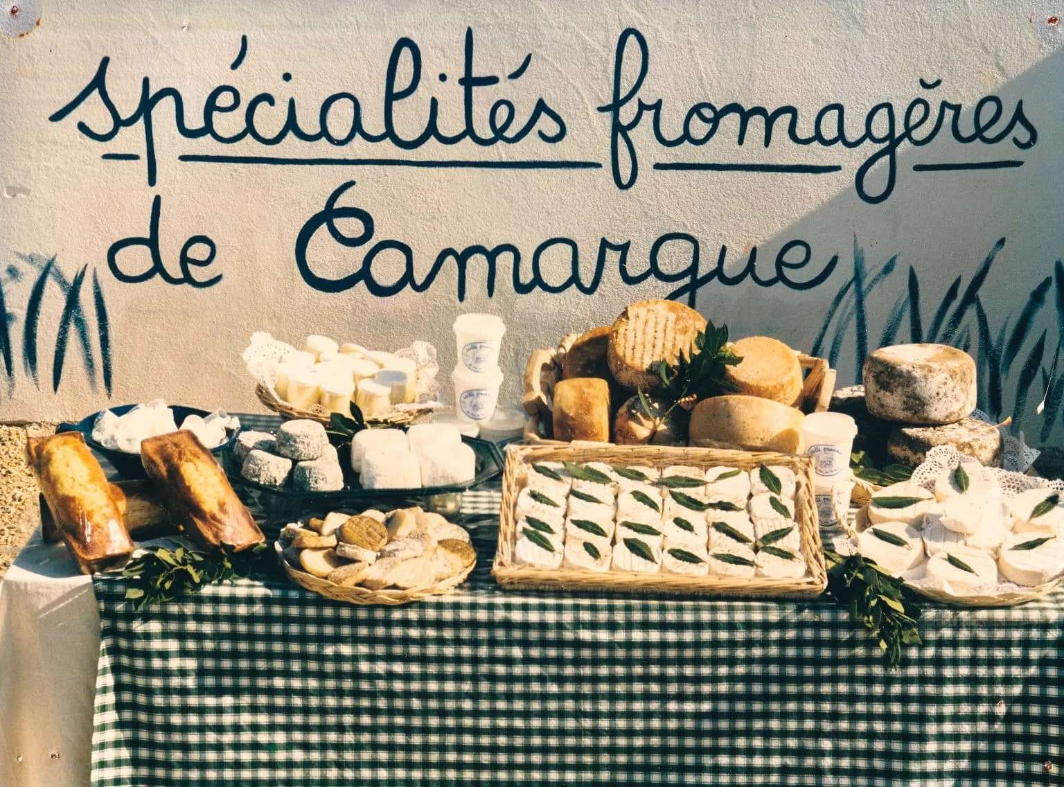 Étal de marché sous l’enseigne « Spécialités fromagères de Camargue »