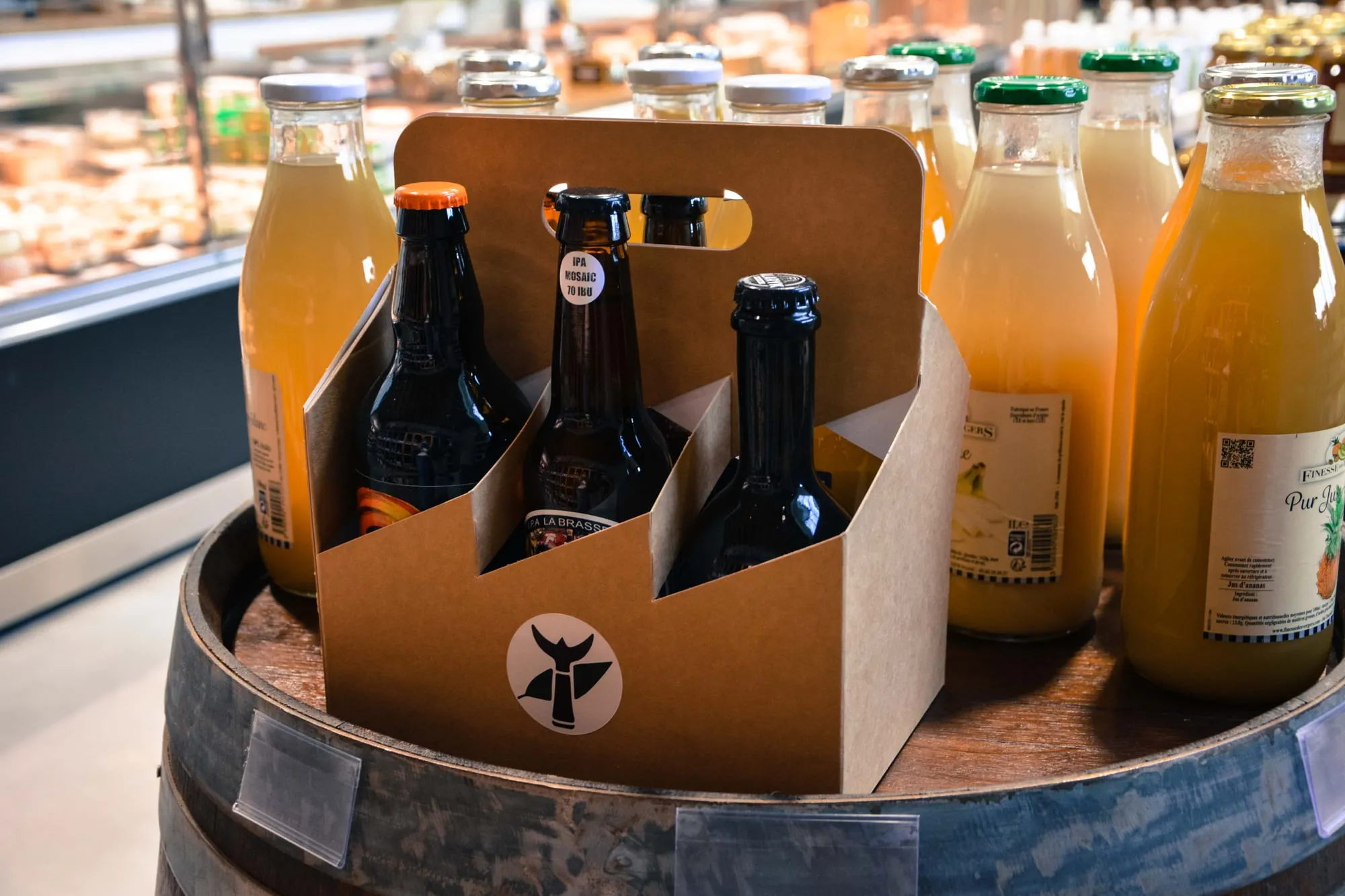Bières et jus de fruits artisanaux présentés sur un tonneau