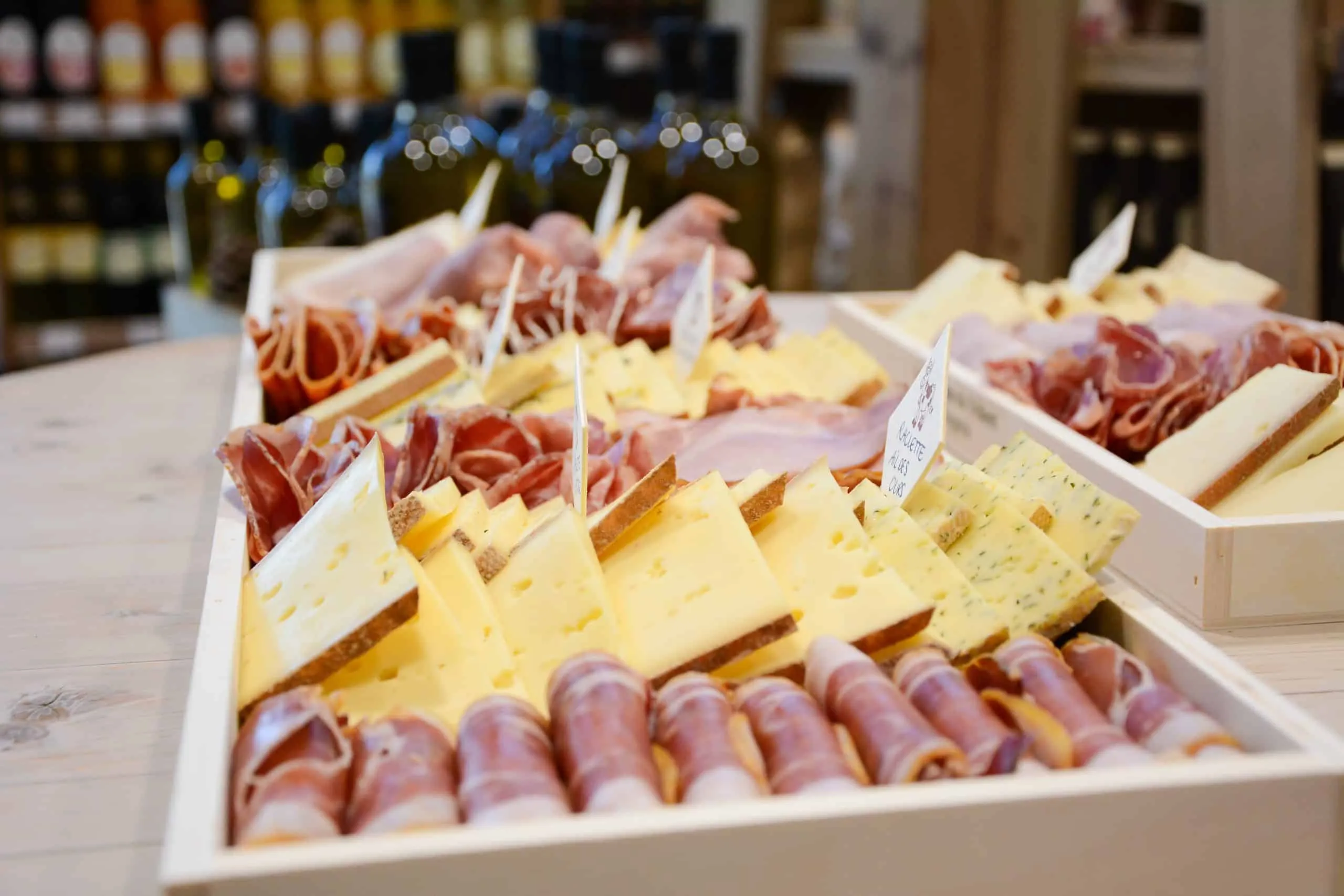 Un plateau de charcuterie tranchée et de fromages, présenté en rangées