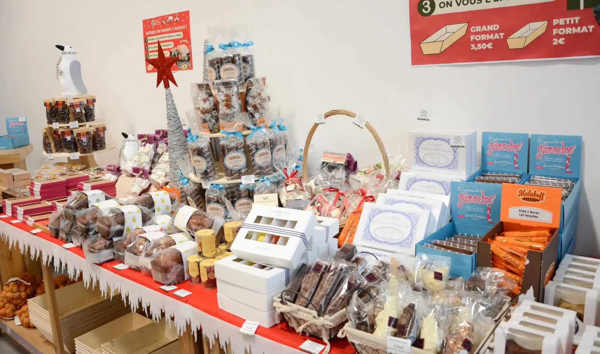 La table de Noël de la boutique, garnie de chocolats, guimauves et paniers garnis