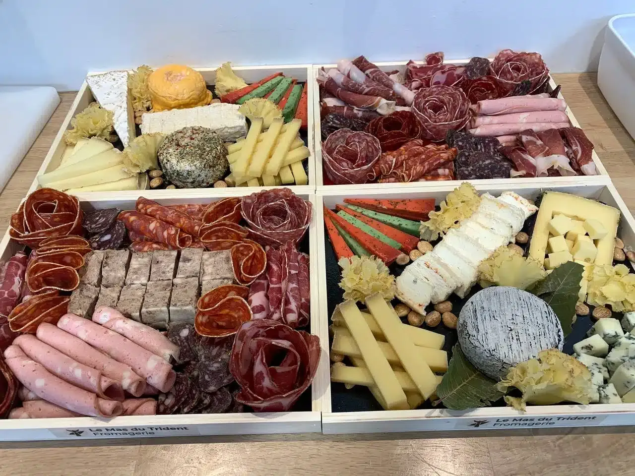 Quatre plateaux du Mas du Trident, fromages et charcuterie disposés en éventail