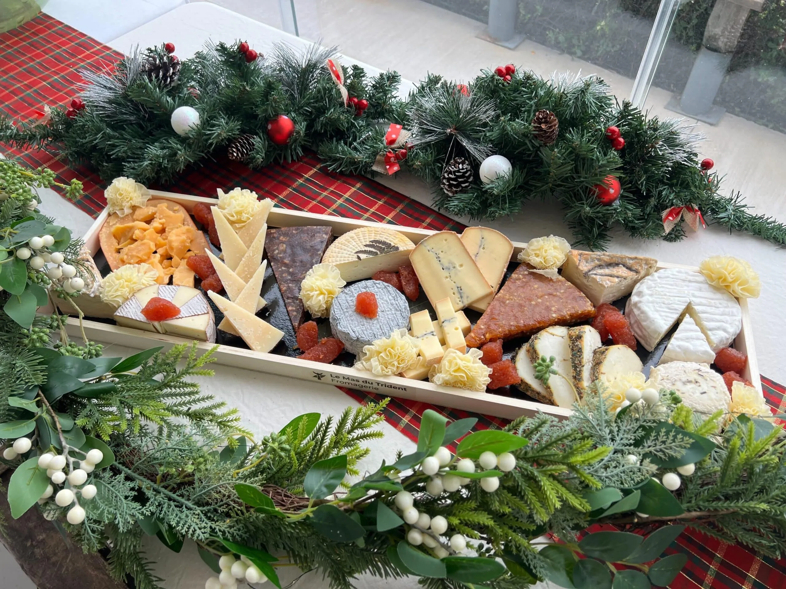 Un plateau de fêtes tout en longueur, posé au milieu d’une guirlande de Noël