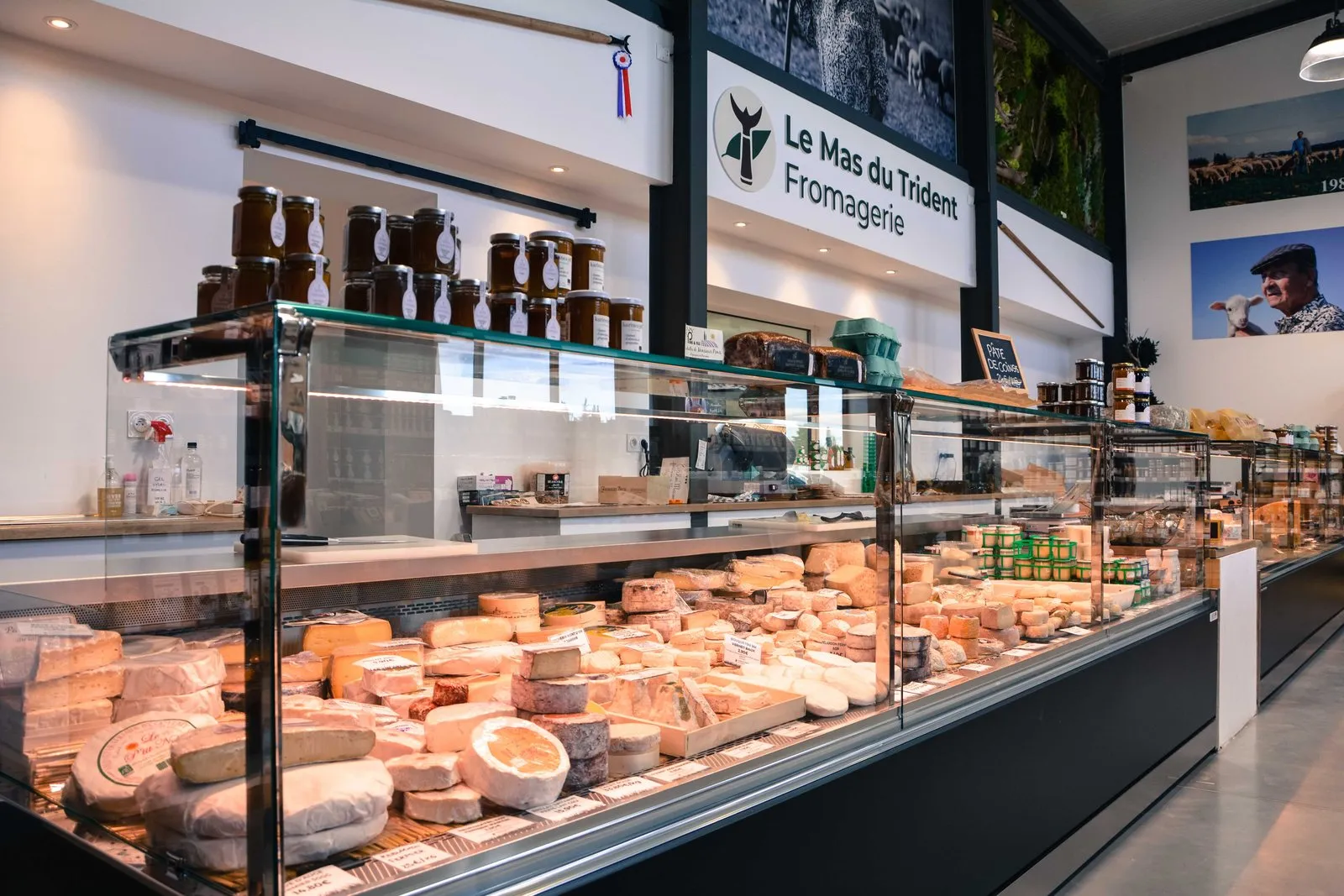 La longue vitrine de fromages de la fromagerie de Vauvert, sous l'enseigne du Mas du Trident.