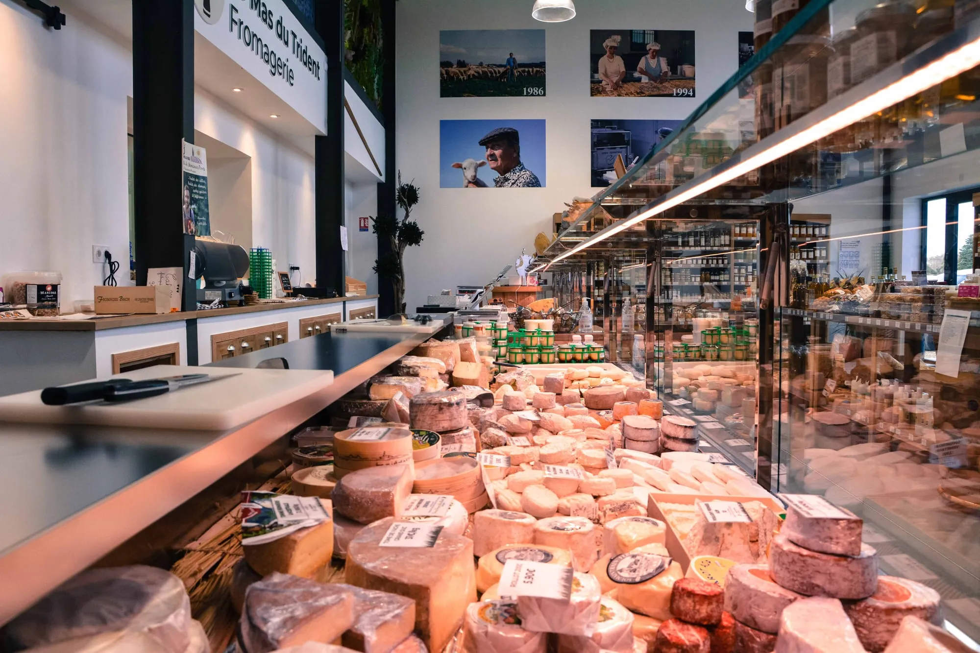 La vitrine à fromages de la fromagerie de Vauvert, vue en enfilade, chaque fromage devant son étiquette